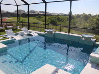 Screened pool with two white in-water loungers and water bowls on a raised wall