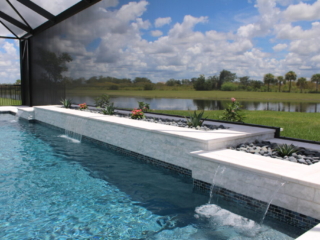Screened pool with a raised planter wall overlooking a lake