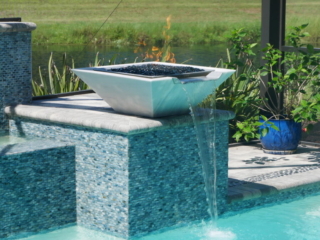White water bowl spilling over a blue-tiled pool wall