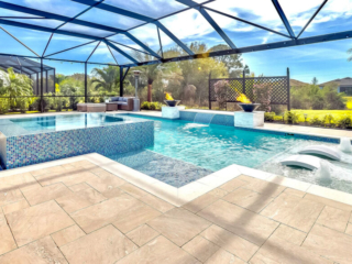 Screened pool with a raised blue-tiled spa, shallow tanning ledge and white loungers